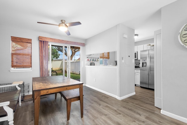 dining area with ceiling fan, light wood-style flooring, and baseboards