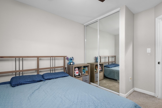 carpeted bedroom featuring baseboards and a closet