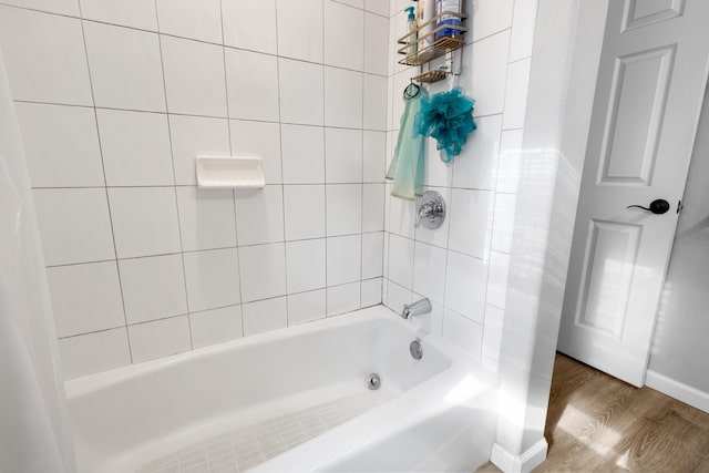 full bath featuring shower / bath combo, baseboards, and wood finished floors