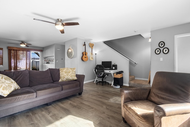 living area with stairs, wood finished floors, a ceiling fan, and baseboards