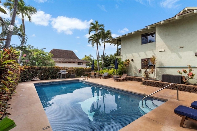 view of pool featuring area for grilling and a patio