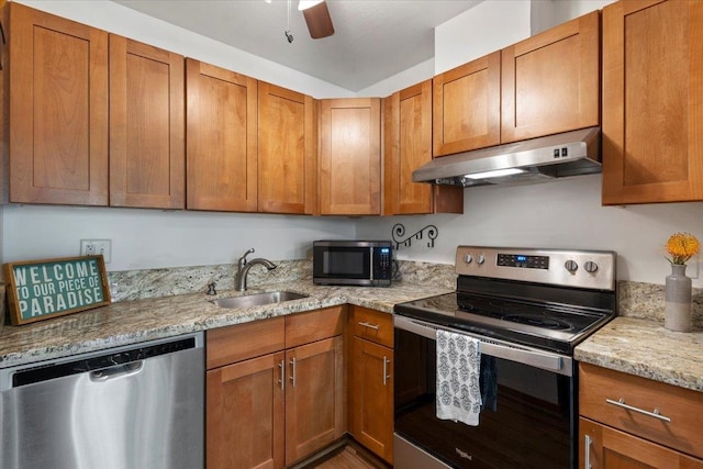 kitchen featuring light stone countertops, sink, ceiling fan, and stainless steel appliances