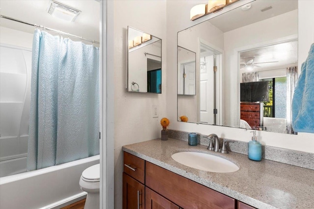 full bathroom featuring ceiling fan, shower / bath combo with shower curtain, vanity, and toilet