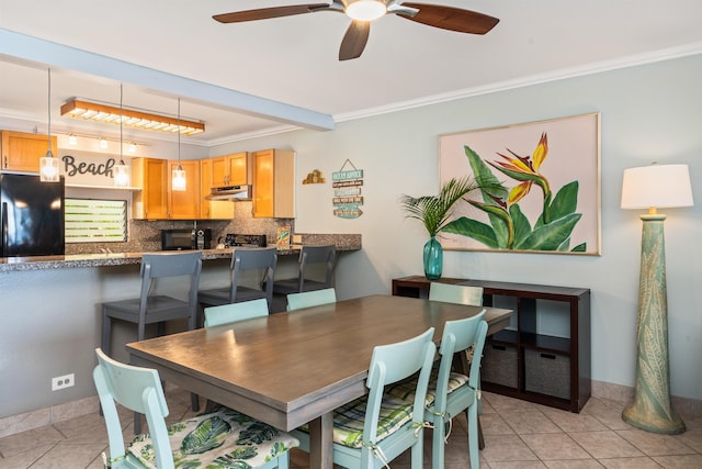 tiled dining area featuring crown molding and ceiling fan