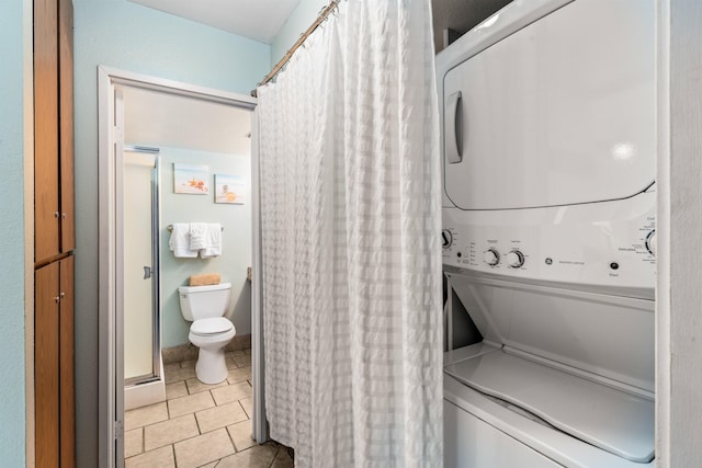 laundry area with light tile patterned floors and stacked washer and clothes dryer