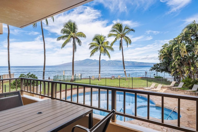 balcony with a patio and a water and mountain view