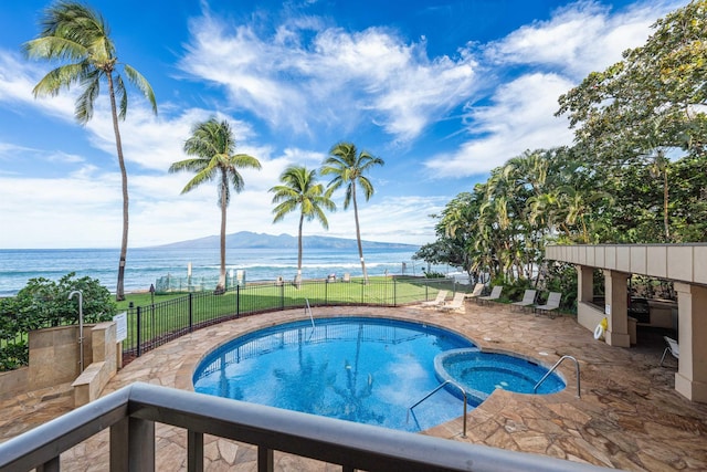 view of pool featuring a community hot tub, a patio, and a water and mountain view