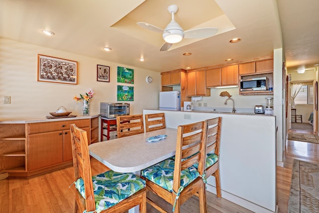 kitchen featuring white refrigerator, ceiling fan, sink, and light hardwood / wood-style floors