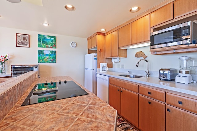 kitchen featuring sink, white appliances, and tile countertops