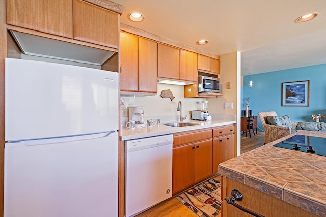 kitchen with sink, white appliances, and light hardwood / wood-style floors