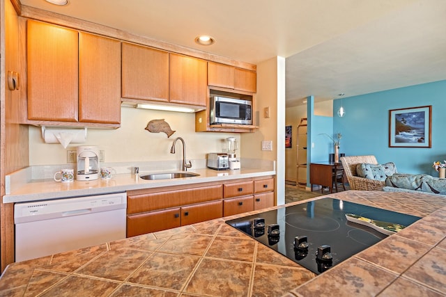 kitchen featuring sink, dishwasher, stainless steel microwave, tile counters, and black electric cooktop