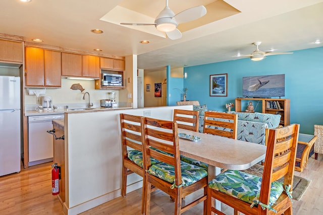 kitchen with ceiling fan, white appliances, sink, and light wood-type flooring