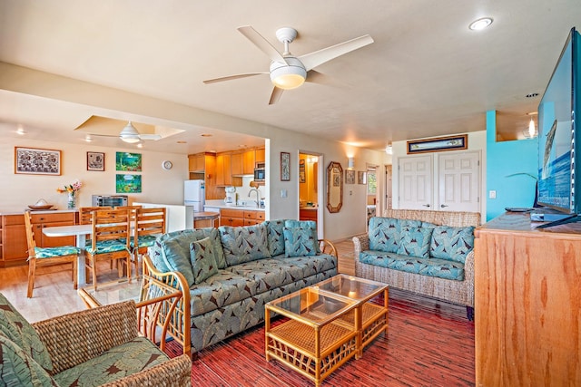 living room featuring sink, hardwood / wood-style floors, and ceiling fan