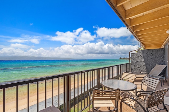 balcony featuring a water view and a beach view