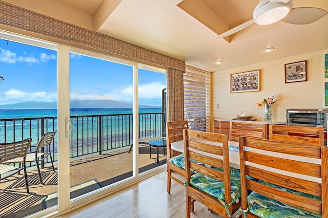 dining area with hardwood / wood-style flooring and a water view