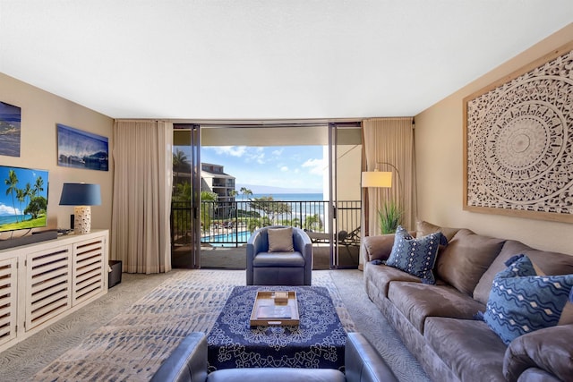 living room with carpet flooring, a wall of windows, and a water view