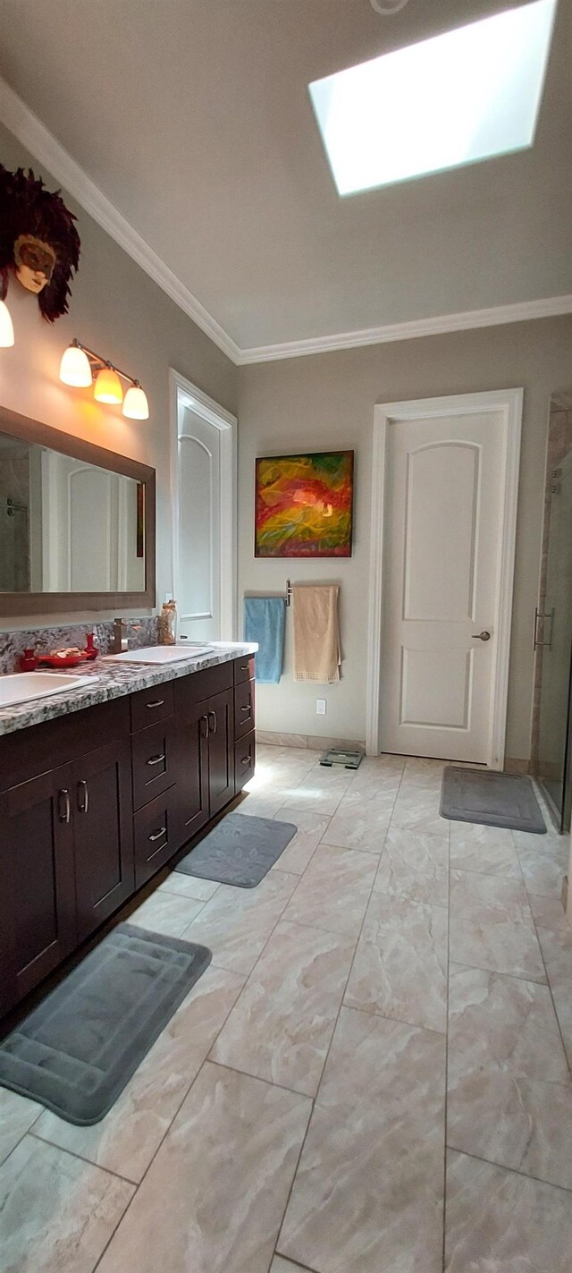 bathroom with vanity, a skylight, a shower with door, and ornamental molding