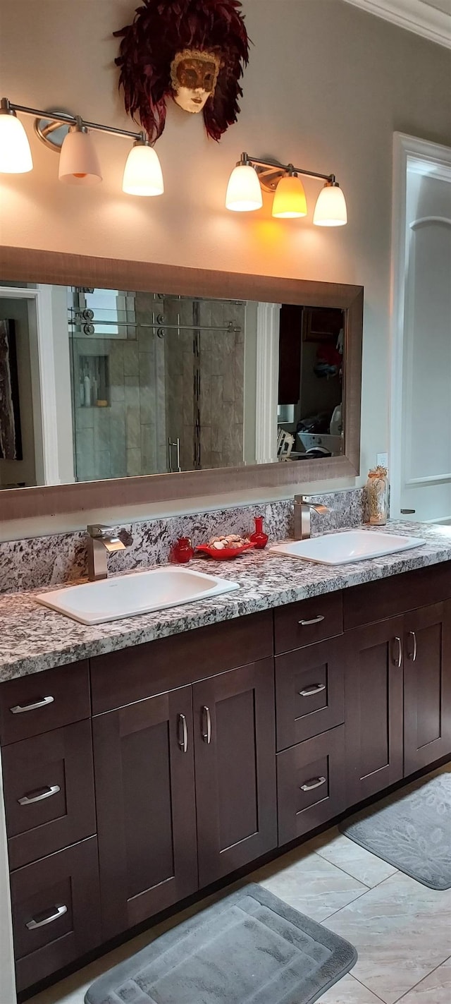 bathroom with tile patterned flooring, vanity, a shower with door, and ornamental molding