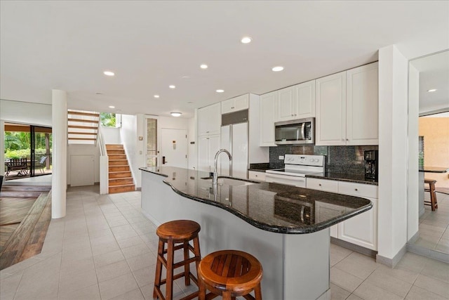 3300 Wailea Alanui St Unit 3A, Kihei, HI 96753 - kitchen with stainless steel microwave, white range with electric cooktop, a sink, built in refrigerator, and light tile patterned floors