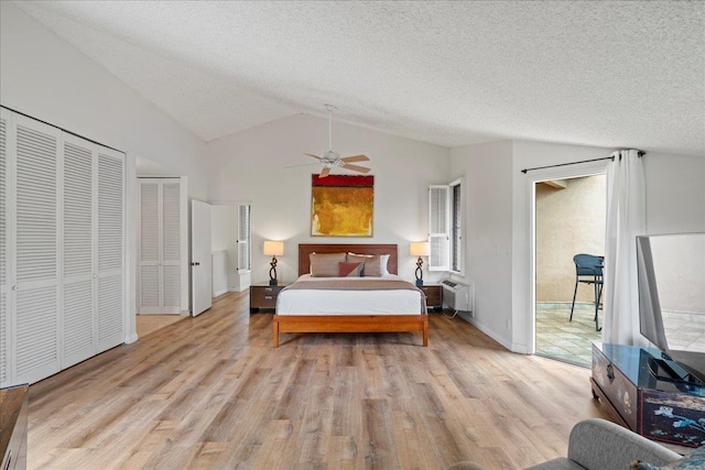 3300 Wailea Alanui St Unit 3A, Kihei, HI 96753 - bedroom with lofted ceiling, wood finished floors, a textured ceiling, access to outside, and a wall mounted air conditioner