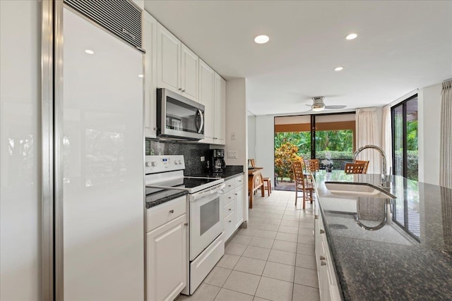 3300 Wailea Alanui St Unit 3A, Kihei, HI 96753 - kitchen with white electric range, stainless steel microwave, a sink, built in fridge, and light tile patterned floors