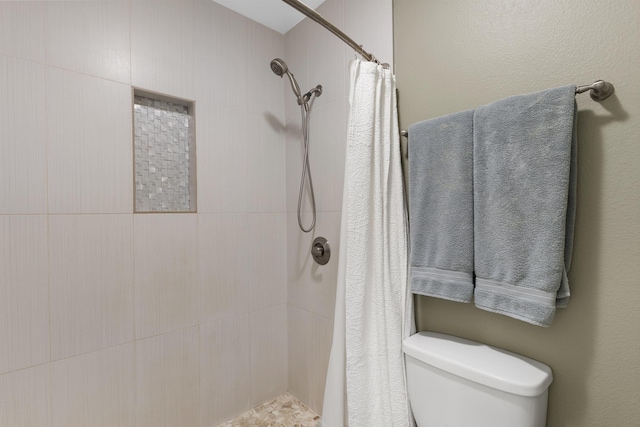 bathroom featuring curtained shower and toilet