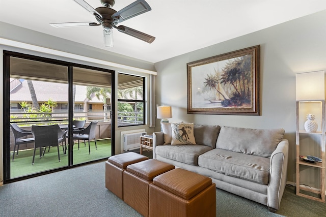 carpeted living room with a wall unit AC and ceiling fan