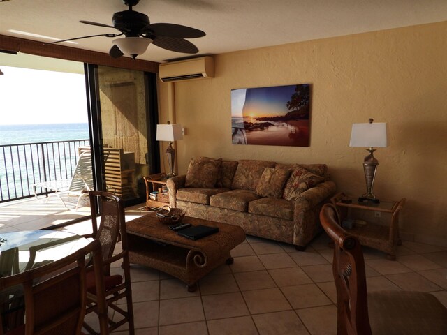 tiled living room featuring ceiling fan, a water view, and an AC wall unit