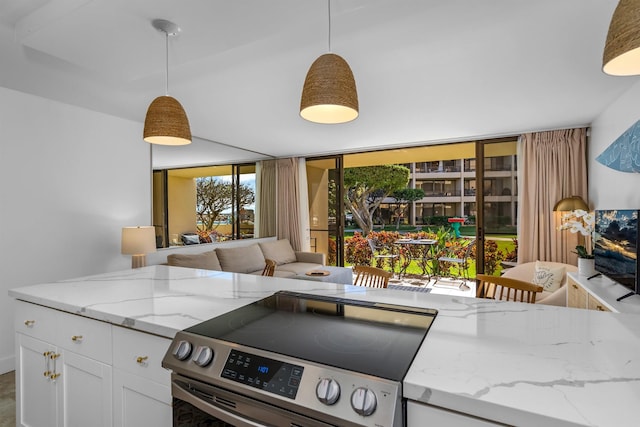 kitchen with stainless steel range with electric stovetop, white cabinets, light stone counters, and hanging light fixtures