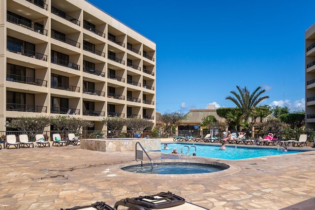 view of pool with a hot tub