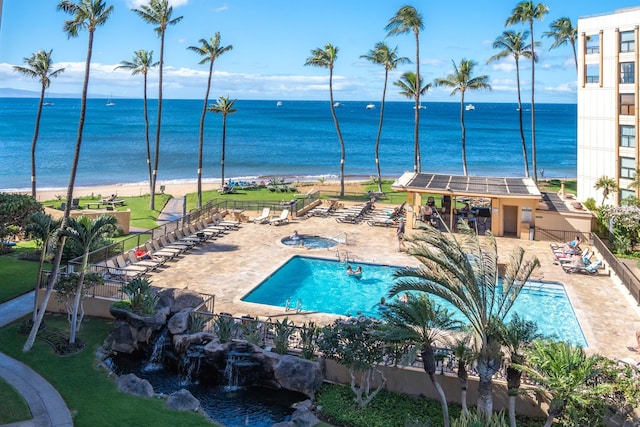 view of pool with a patio area and a water view