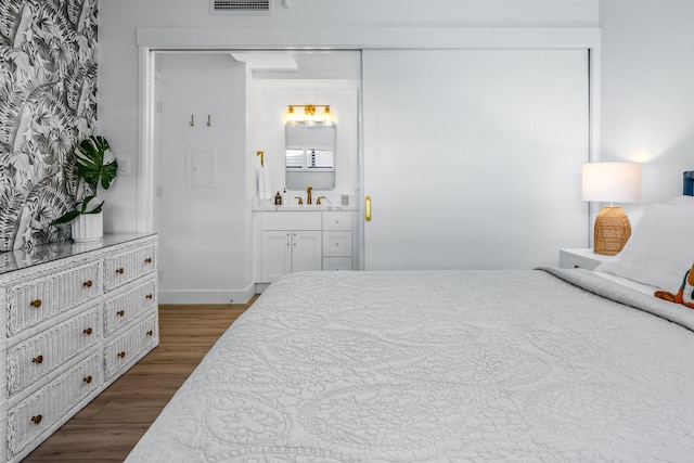 bedroom featuring dark hardwood / wood-style floors and ensuite bath