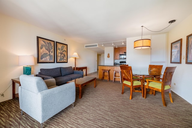 living area with visible vents, rail lighting, and carpet floors