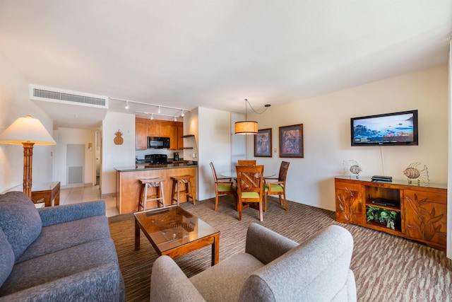 living room featuring rail lighting, visible vents, and light carpet