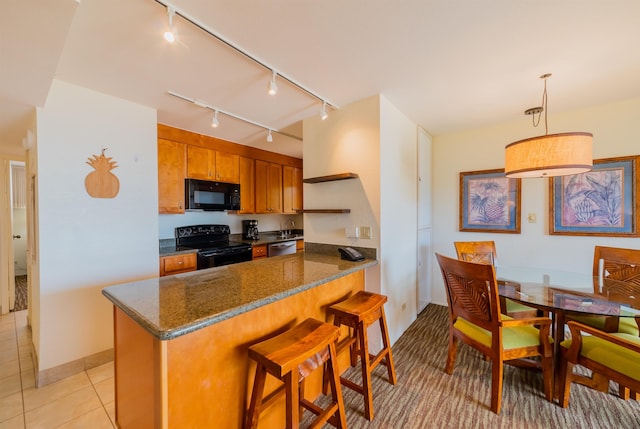 kitchen featuring a kitchen breakfast bar, brown cabinetry, black appliances, track lighting, and a peninsula