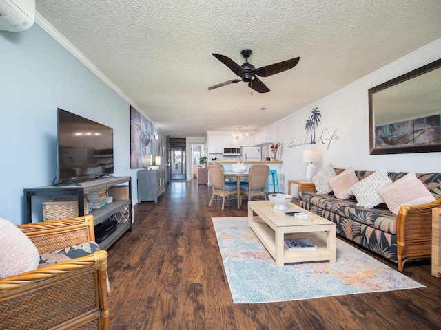 living room featuring ceiling fan, dark wood-type flooring, an AC wall unit, a textured ceiling, and ornamental molding