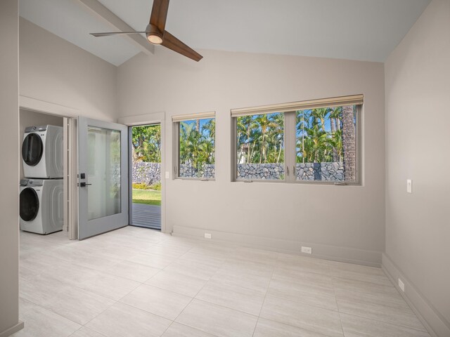 empty room with stacked washer / dryer, high vaulted ceiling, baseboards, light tile patterned flooring, and a ceiling fan