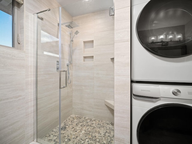 bathroom with stacked washer / dryer and a stall shower