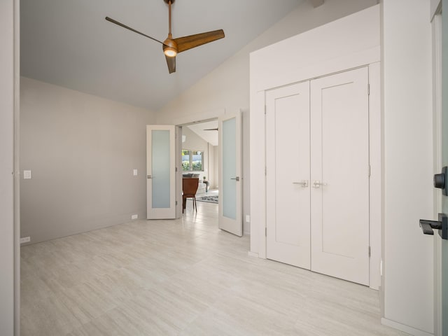 unfurnished bedroom featuring a closet, a ceiling fan, baseboards, and high vaulted ceiling