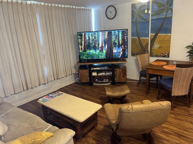 living area with baseboards and wood finished floors