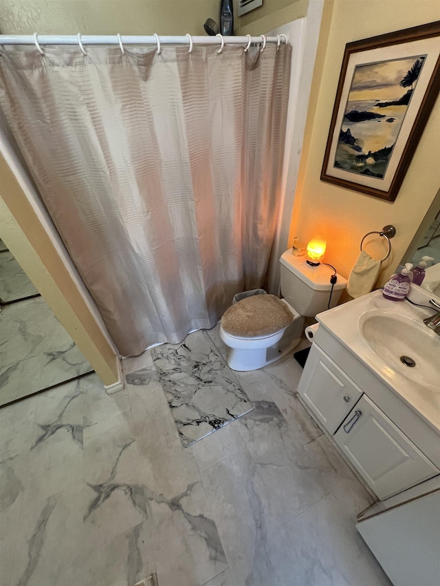 bathroom with a shower with curtain, toilet, marble finish floor, and vanity