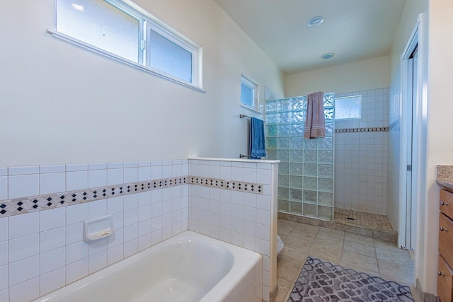 bathroom featuring vanity, tile walls, independent shower and bath, and tile patterned floors