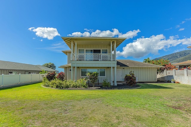 rear view of property with a lawn and a balcony