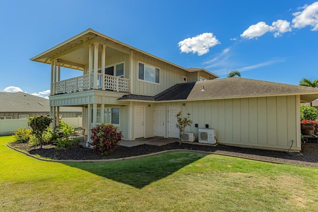 back of property featuring a balcony, a lawn, and ac unit