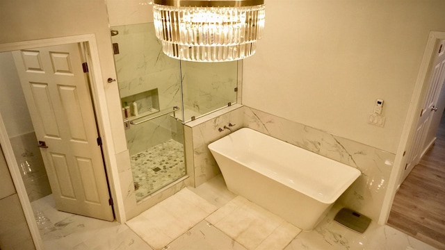 11 Piina Pl, Lahaina, HI 96761 - bathroom with marble look tiles, a marble finish shower, a freestanding tub, tile walls, and a chandelier