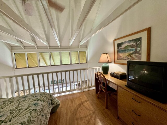 interior space with hardwood / wood-style flooring, vaulted ceiling with beams, and built in desk