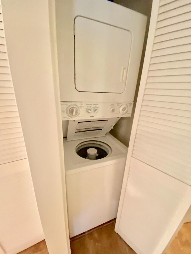 laundry area featuring hardwood / wood-style flooring and stacked washer and dryer