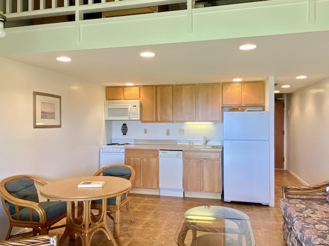 kitchen with light tile patterned floors, sink, white appliances, and light brown cabinets