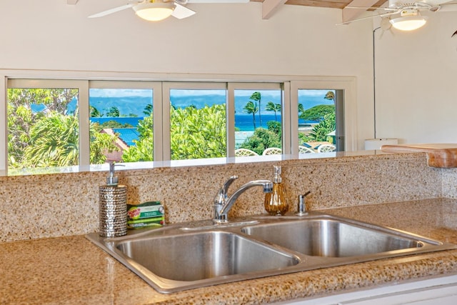 kitchen with backsplash, beam ceiling, sink, and ceiling fan