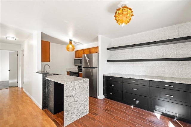 kitchen with stainless steel appliances, a peninsula, a sink, dark wood-style floors, and open shelves